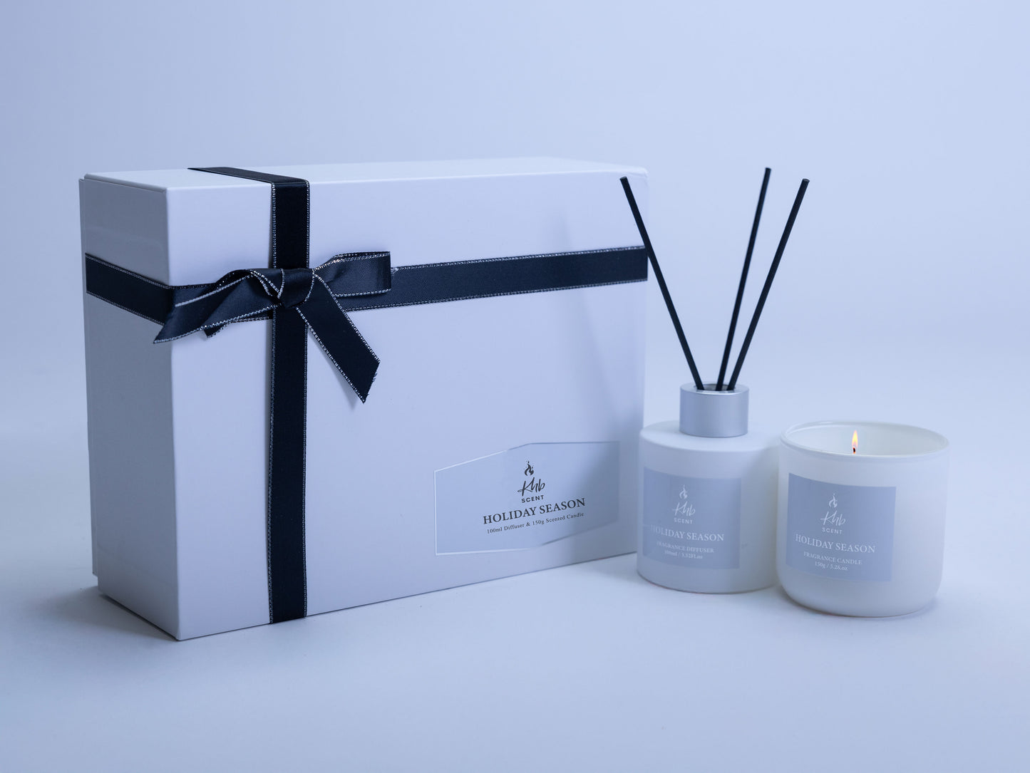 Holiday season oud and bergamot candle and reed diffuser gift set in elegant white packaging