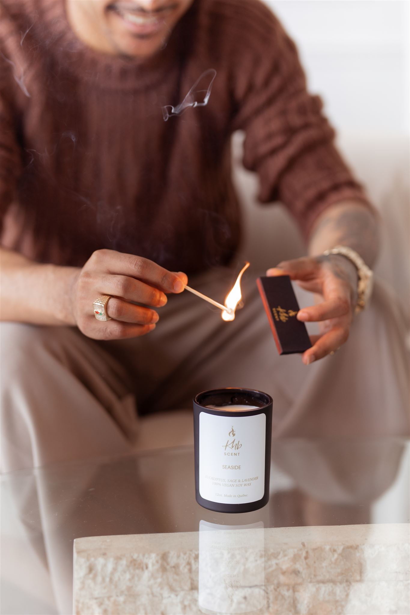 Person lighting a candle using wooden matches for candles, creating a warm ambiance