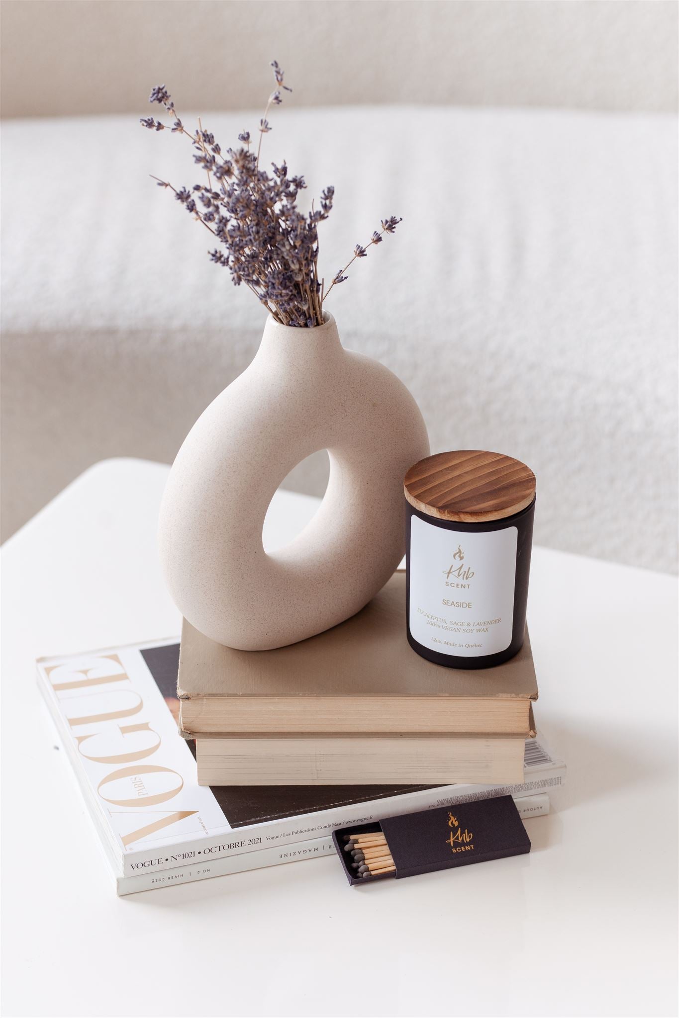 Elegant setup with KHB SCENT candle, vase with flowers, and wooden matches for candles on a stylish table